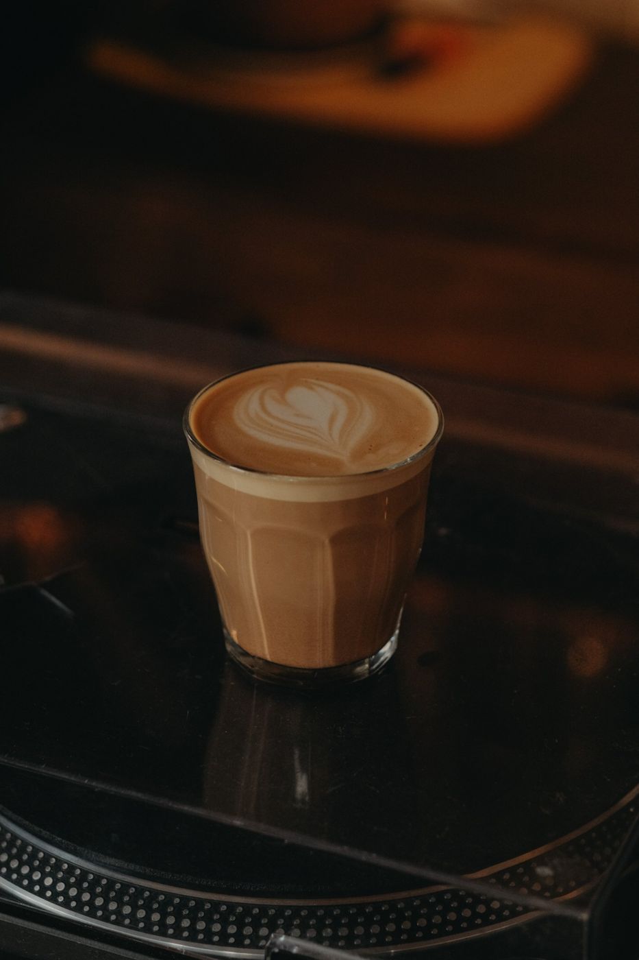 A latte in a glass on a turntable