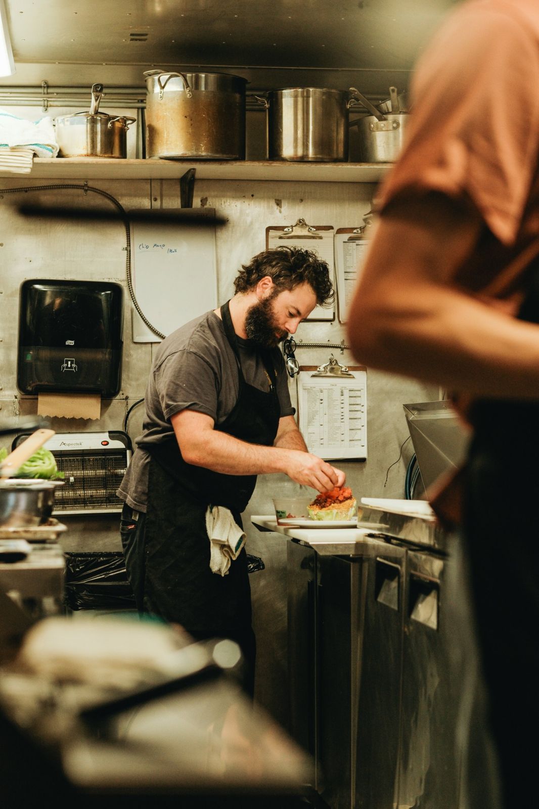 A cook plating a wedge salad in the Cassette kitchen
